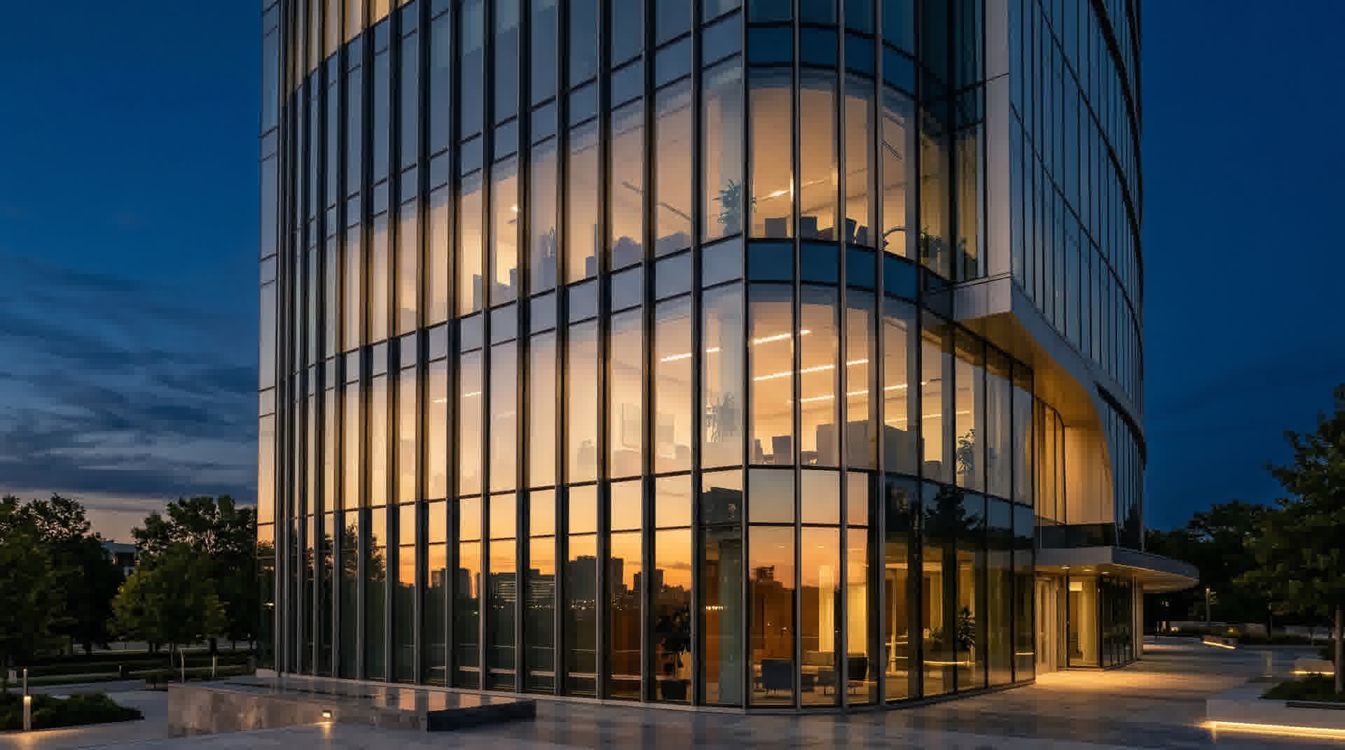 Modern glass office building at twilight reflecting warm golden light